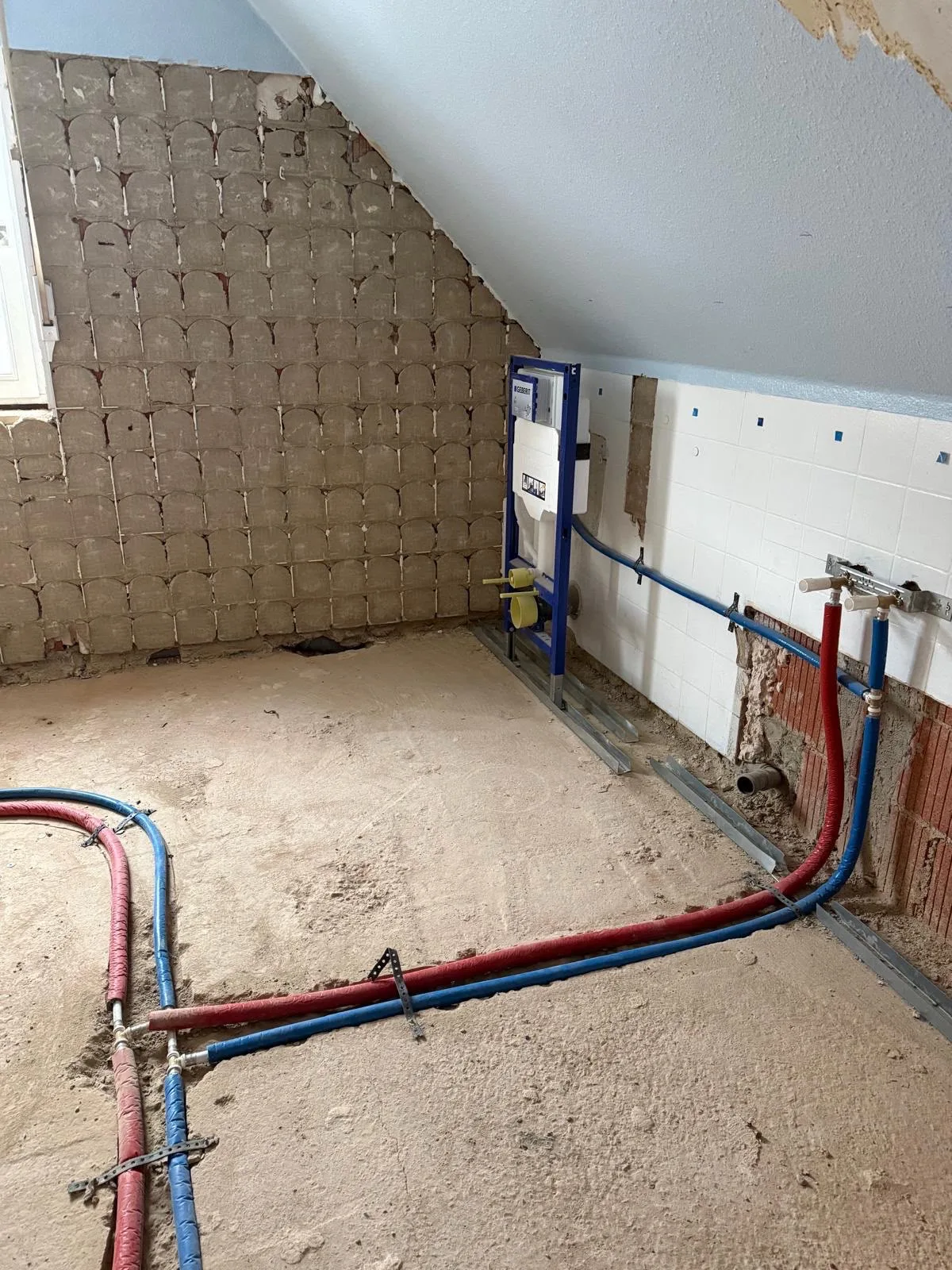 Badbereich während der Sanierung mit freigelegten Leitungen und Vorwandinstallation